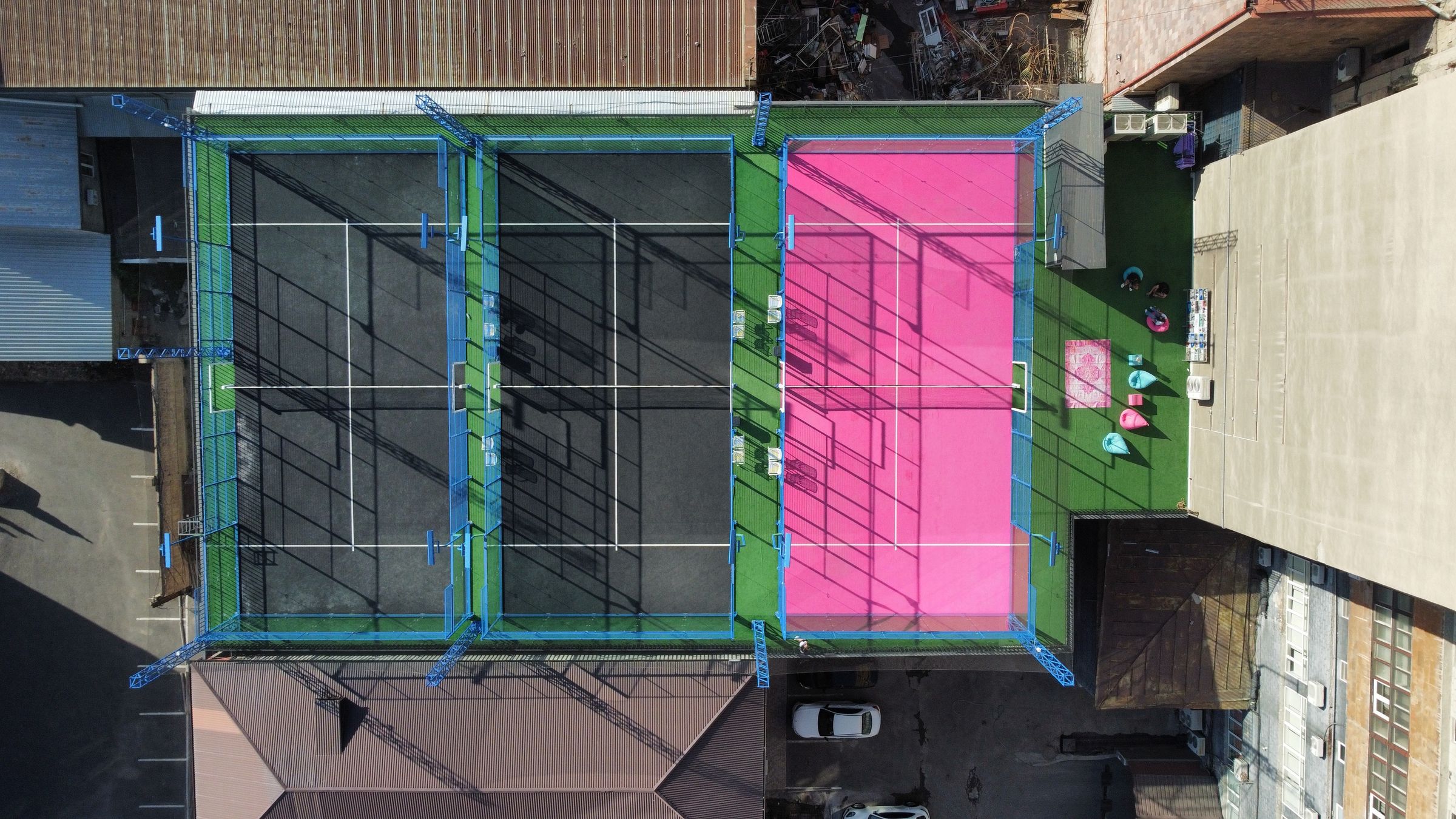 PADEL BATTLE rooftop from above: the pink court and two black courts