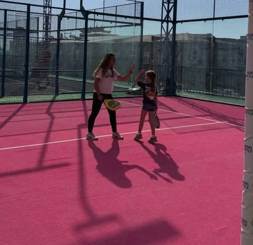 Coach and a girl on the pink court